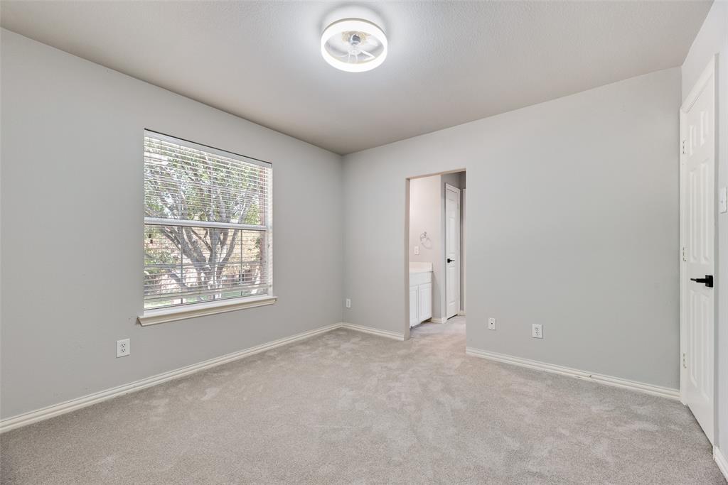 Neutral-toned room featuring neutral carpeting, a dual-function ceiling light and fan fixture, and a single-panel window with horizontal blinds