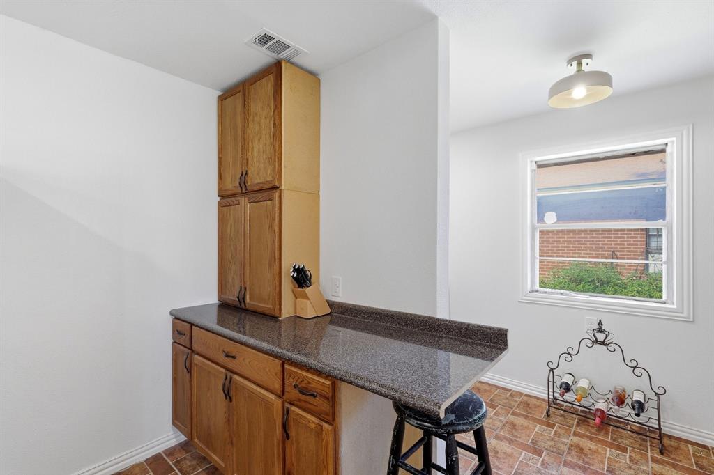 Built-in wood cabinetry with stone-surface countertop, tile flooring, and overhead dome lighting