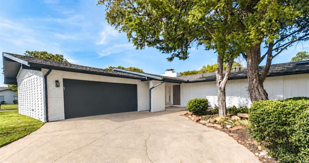 This Mid-century modern home, built in1960, features white painted brick masonry, vertical wood-panel siding, attached two-car garage, and low-pitch roofline This Mid-century modern home, built in1960, features white painted brick masonry, vertical wood-panel siding, attached two-car garage, and low-pitch roofline