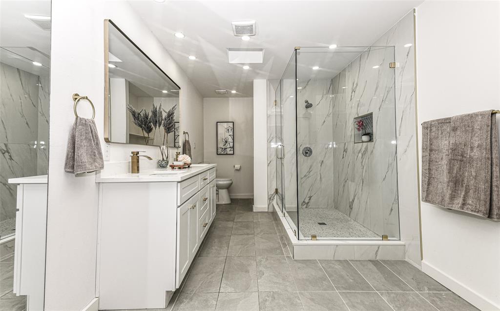 The shower is a piece of art work with its glass-enclosure, tiled surround and stone-pattern wall cladding