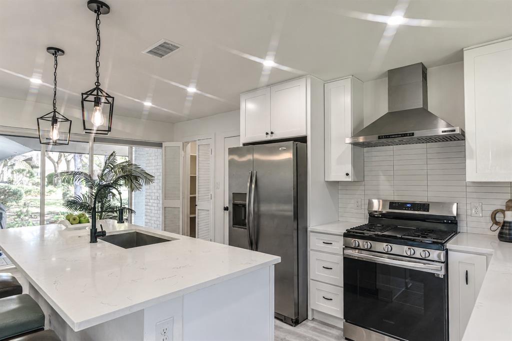Oversized Island with quartz countertop with matte black faucet and gas range is a Chefs dream Oversized Island with quartz countertop with matte black faucet and gas range is a Chefs dream