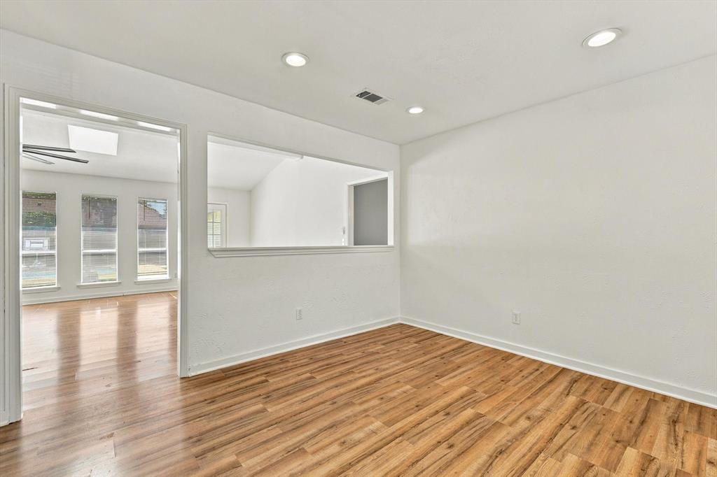 Interior space featuring wood-finish flooring, recessed lighting, and a window-style pass-through opening
