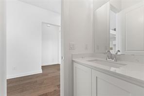 White vanity with an integrated basin, light-toned stone countertop, polished chrome faucet, and large rectangular mirror