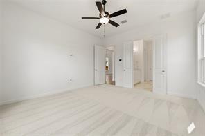Interior room featuring high ceilings, neutral wall-to-wall carpeting, and a multi-blade ceiling fan with integrated lighting