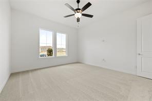 Neutral-toned carpeting, dual-pane windows, a multi-blade ceiling fan with integrated lighting, and a solid-core interior door