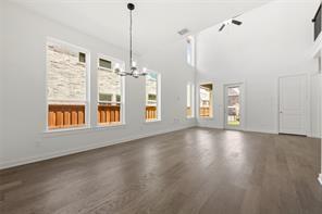 Vaulted ceilings, wood-finish flooring, multi-pane windows, and a multi-arm chandelier