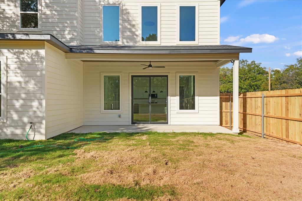 Covered patio featuring a concrete slab foundation, installed ceiling fan, horizontal lap siding, vertical glass sliding doors, and tall rectangular windows