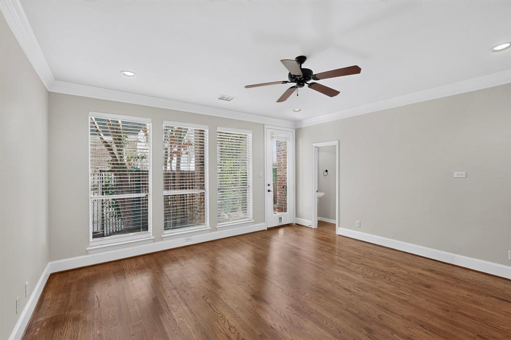 Living area featuring wood-finish flooring, crown molding, recessed lighting, a ceiling fan, and large windows with horizontal blinds