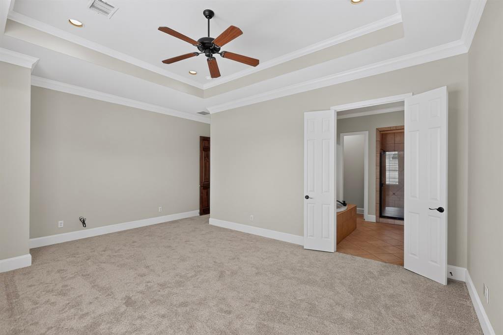 Tray ceiling with crown molding, ceiling-mounted fan, recessed lighting, and carpeted flooring