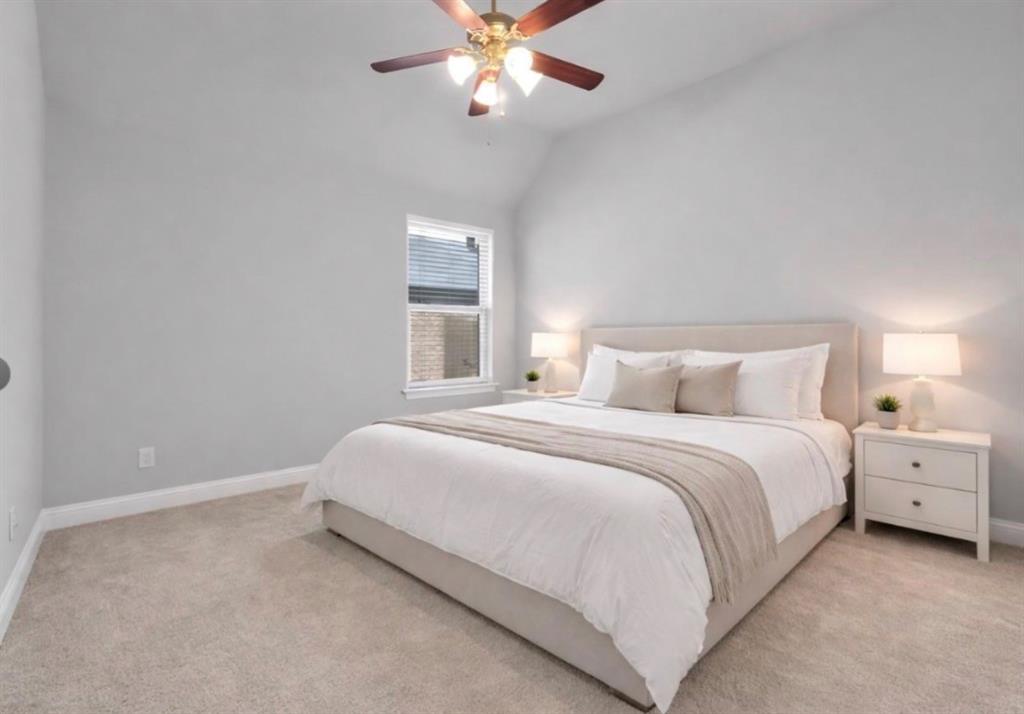 Vaulted ceiling featuring a central multi-blade ceiling fan with integrated light fixture and neutral wall-to-wall carpeting