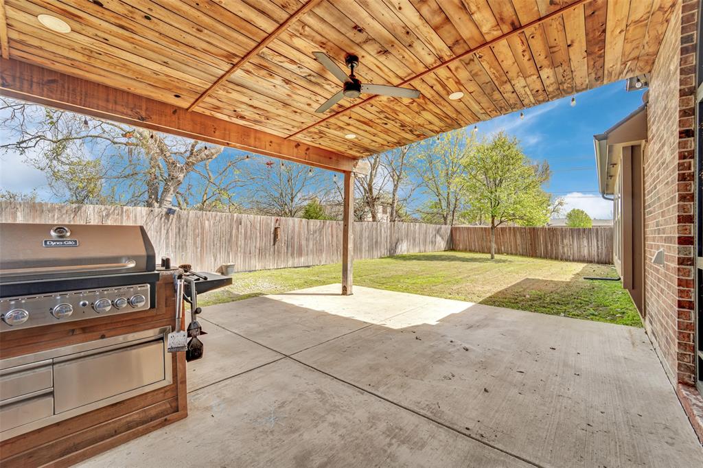 Covered patio featuring a wood-plank ceiling, ceiling fan, recessed lighting, integrated stainless steel grill, and concrete flooring