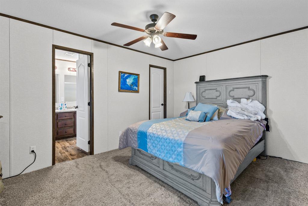 Room featuring wall-to-wall carpeting, wood-trim detailing, and a ceiling fan with integrated lighting