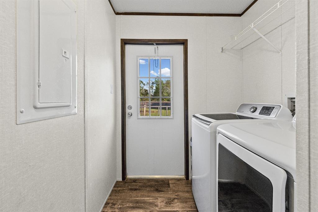 Utility room featuring wood-finish flooring, a six-pane windowed exterior door, and built-in wire shelving