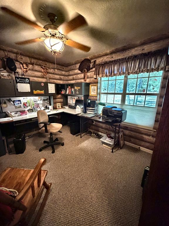 Log wall interior featuring a multi-pane window, built-in cabinetry, and a ceiling fan with light fixture