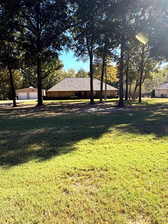 Expansive lot featuring mature trees, multi-structure property layout, and detached garage