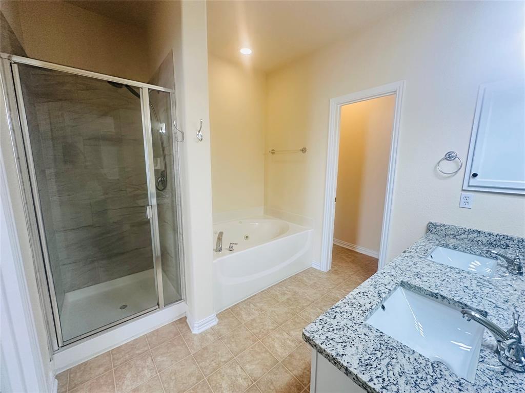Bathroom featuring vanity, independent shower and bath, and tile patterned flooring