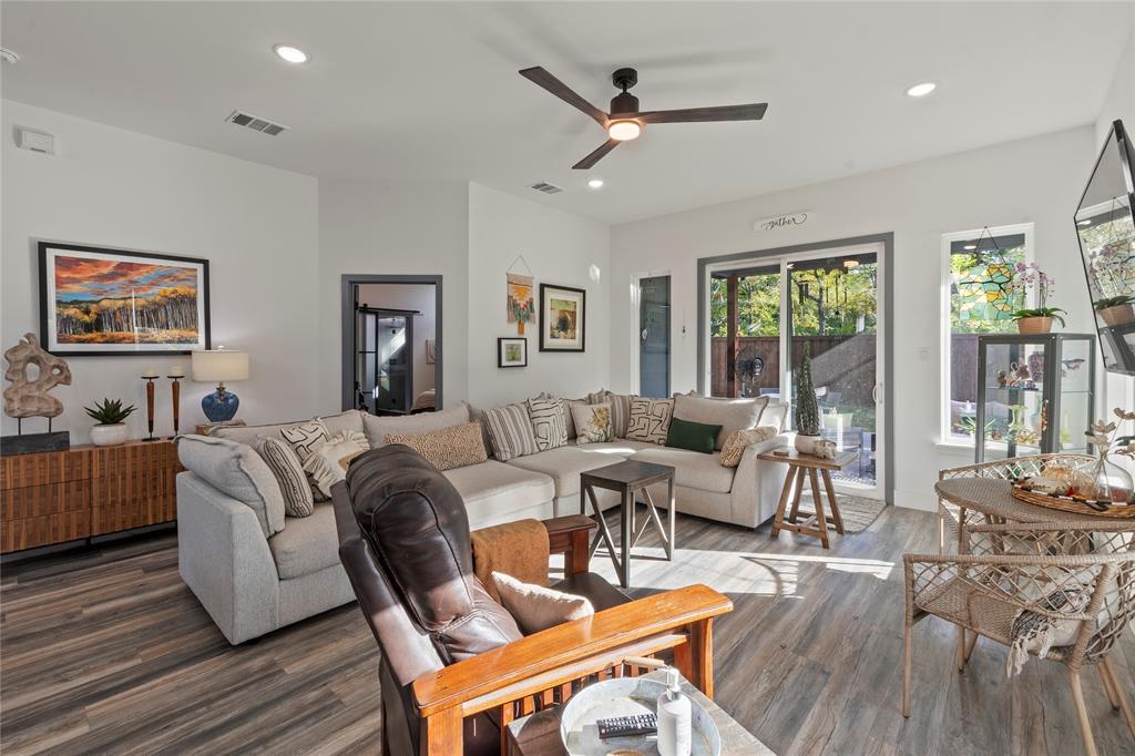 Living area featuring wood-finish flooring, recessed lighting, a ceiling fan with integrated lighting, and a sliding glass door Living area featuring wood-finish flooring, recessed lighting, a ceiling fan with integrated lighting, and a sliding glass door