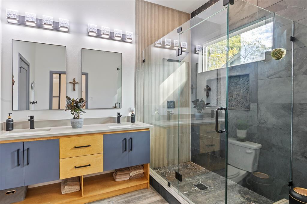 Dual-sink vanity featuring a light-toned countertop, custom two-tone cabinetry, and matte black hardware Dual-sink vanity featuring a light-toned countertop, custom two-tone cabinetry, and matte black hardware