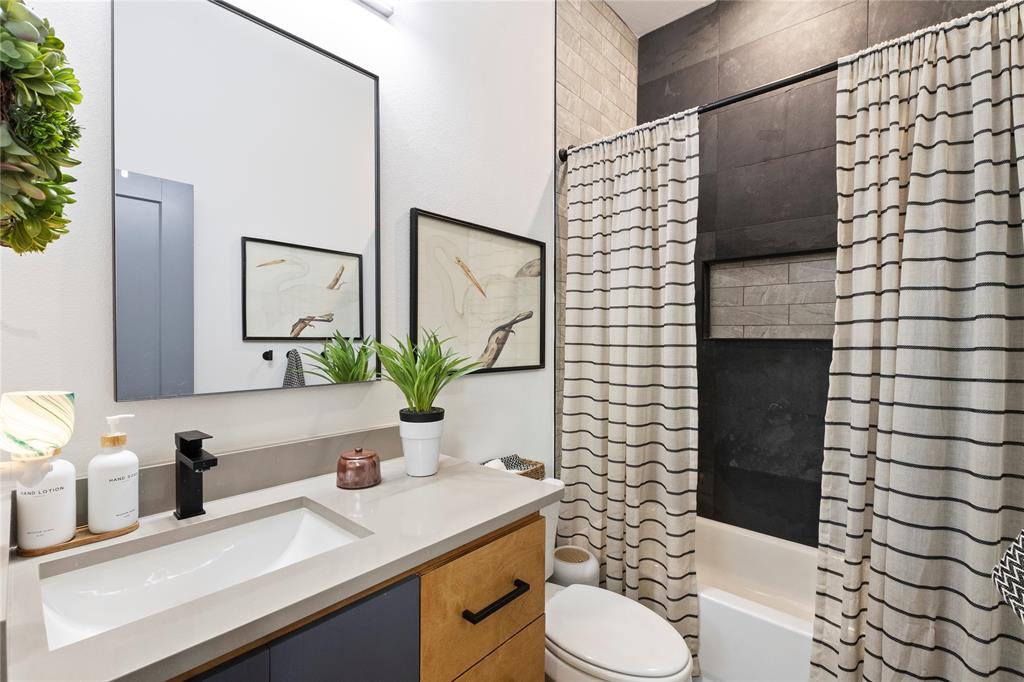 Modern vanity with a light-toned solid surface countertop, matte black faucet, rectangular undermount sink, and dual-tone cabinetry featuring black hardware Modern vanity with a light-toned solid surface countertop, matte black faucet, rectangular undermount sink, and dual-tone cabinetry featuring black hardware