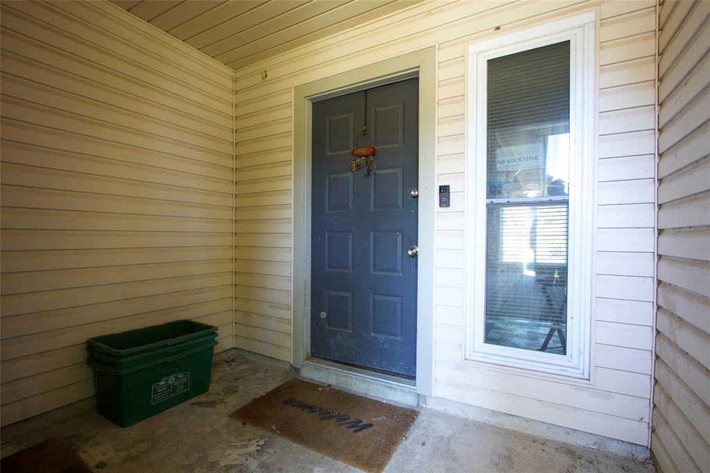 Covered entryway featuring horizontal siding, a six-panel dark gray door, and a full-length sidelight window