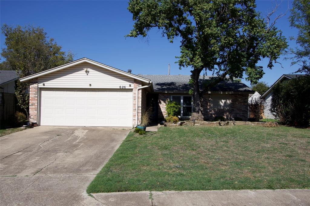 Single-story residence featuring a brick and horizontal siding exterior, a two-car attached garage, and a mature tree