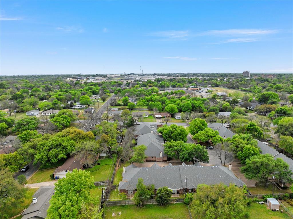 Aerial perspective of the property featuring a multi-pitched shingled roofline and mature canopy trees