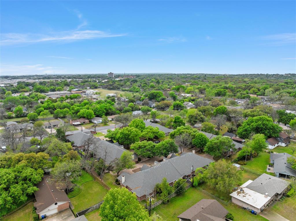 Aerial perspective featuring a residential lot with mature trees and expansive green space