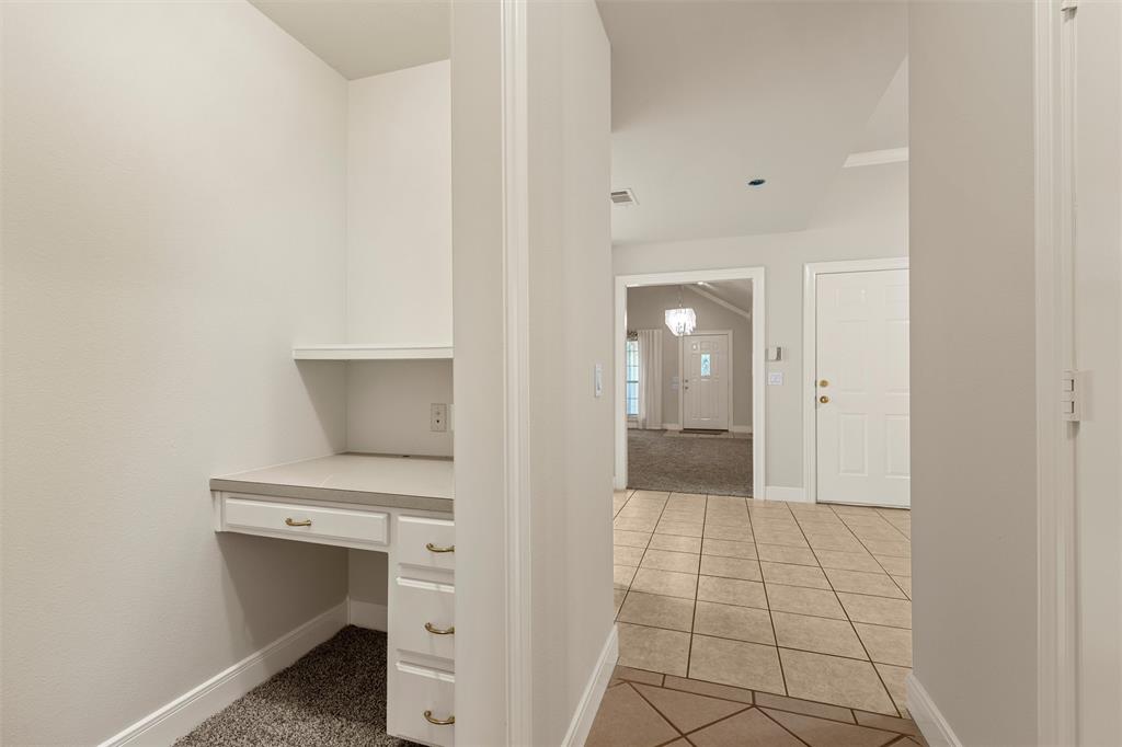 Built-in desk featuring white cabinetry, drawers, and a solid-surface countertop with an integrated upper shelf Built-in desk featuring white cabinetry, drawers, and a solid-surface countertop with an integrated upper shelf