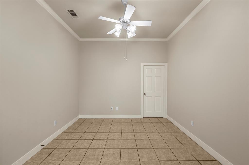 Room featuring neutral-toned walls, tile flooring, high ceilings with crown molding, and a four-blade ceiling fan with integrated lighting