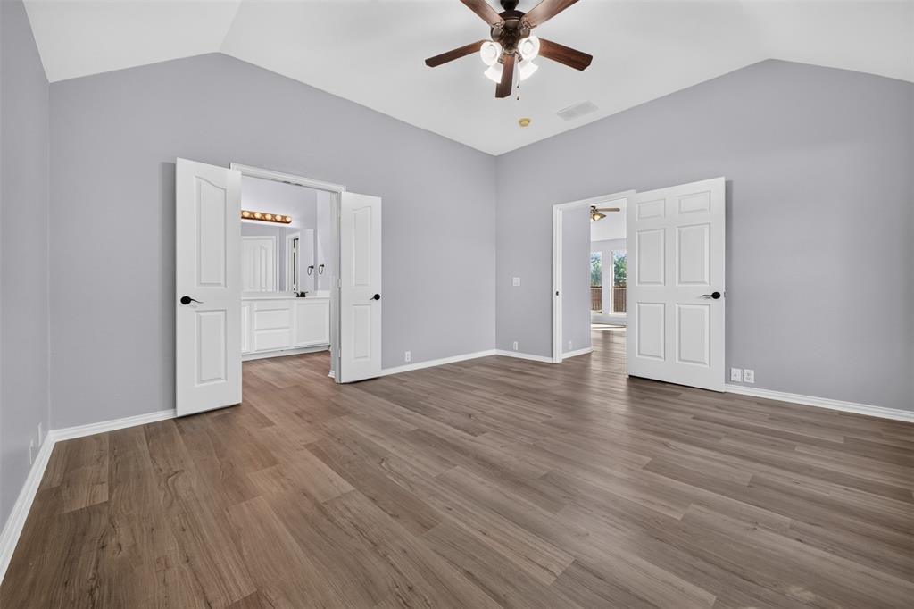 Vaulted ceilings, wood-finish flooring, and a ceiling fan with integrated lighting