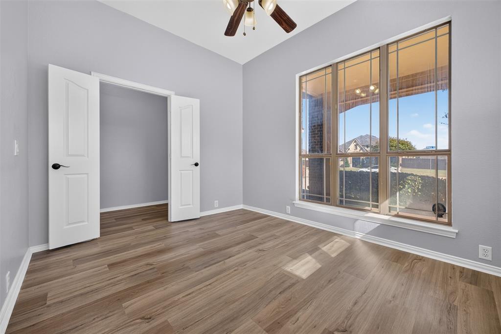 Wood-finish flooring, vaulted ceiling, large grid-pattern windows, and dual-panel interior doors
