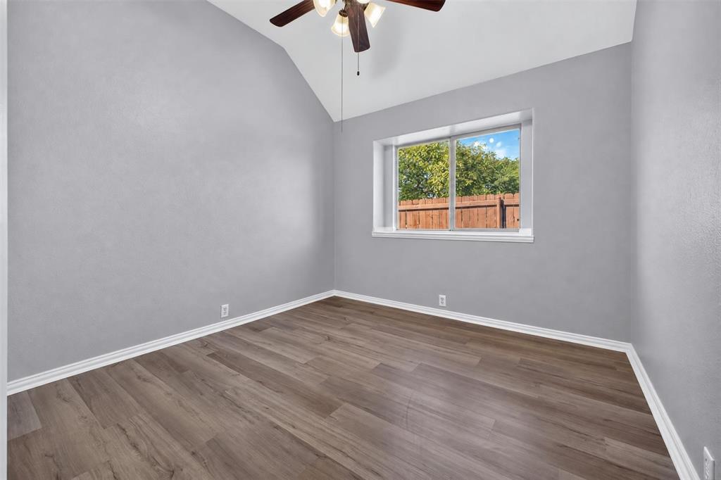 Vaulted ceiling, wood-finish flooring, and a multi-light ceiling fan