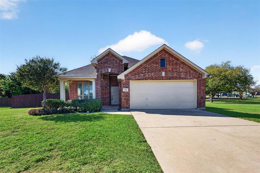 Single-story brick exterior featuring a multi-gable roofline, attached two-car garage, concrete driveway, and covered front entry
