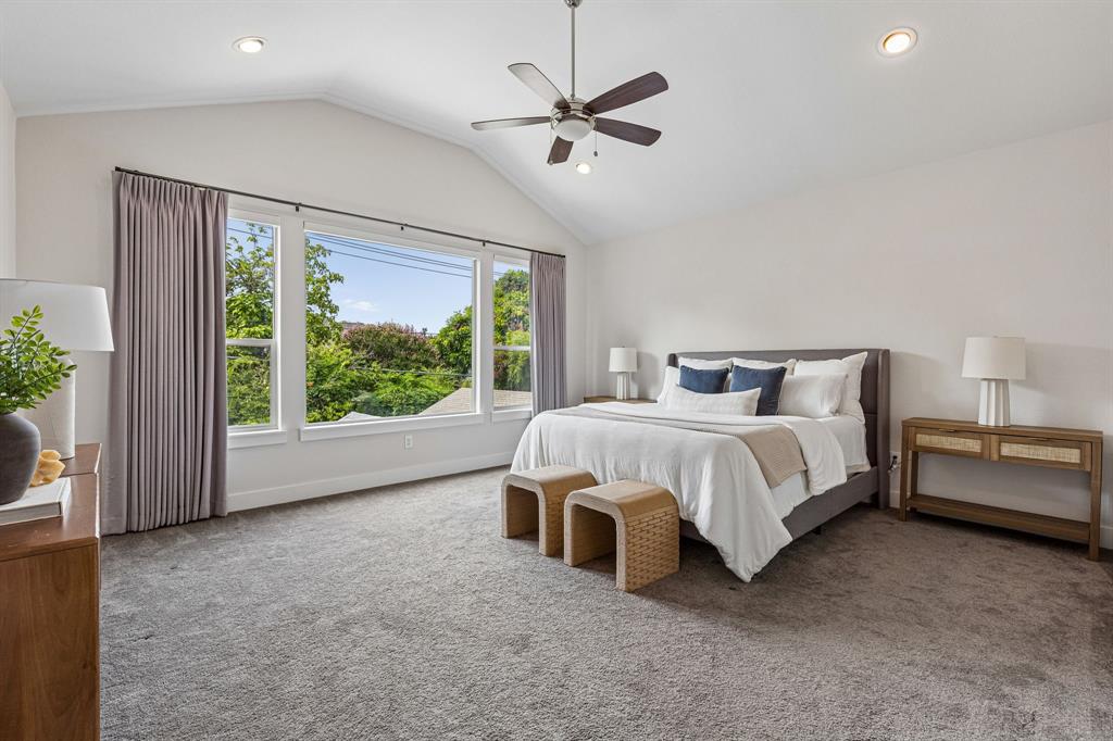 Vaulted ceilings, large triple-pane windows, recessed lighting, and a ceiling fan