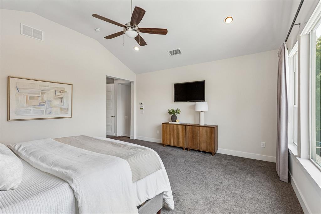 Vaulted ceilings, carpeted flooring, and a multi-blade ceiling fan with integrated lighting
