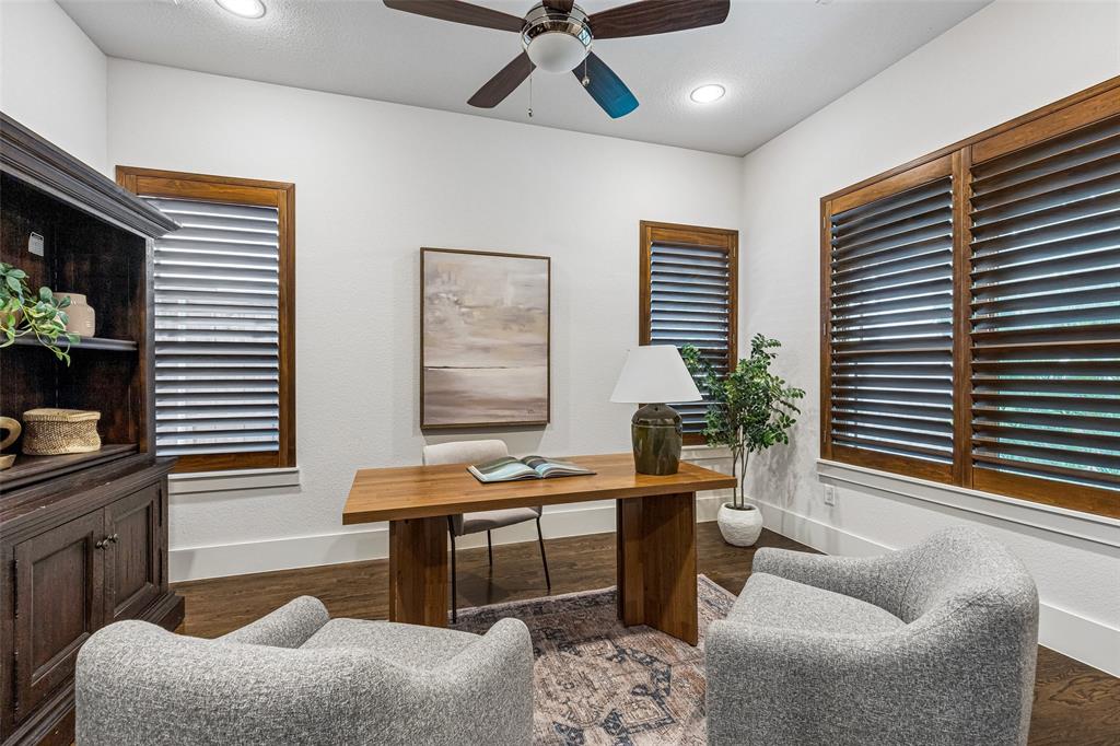 Room featuring wood-finish flooring, recessed lighting, a ceiling fan with integrated light fixture, and wood-framed windows outfitted with plantation shutters