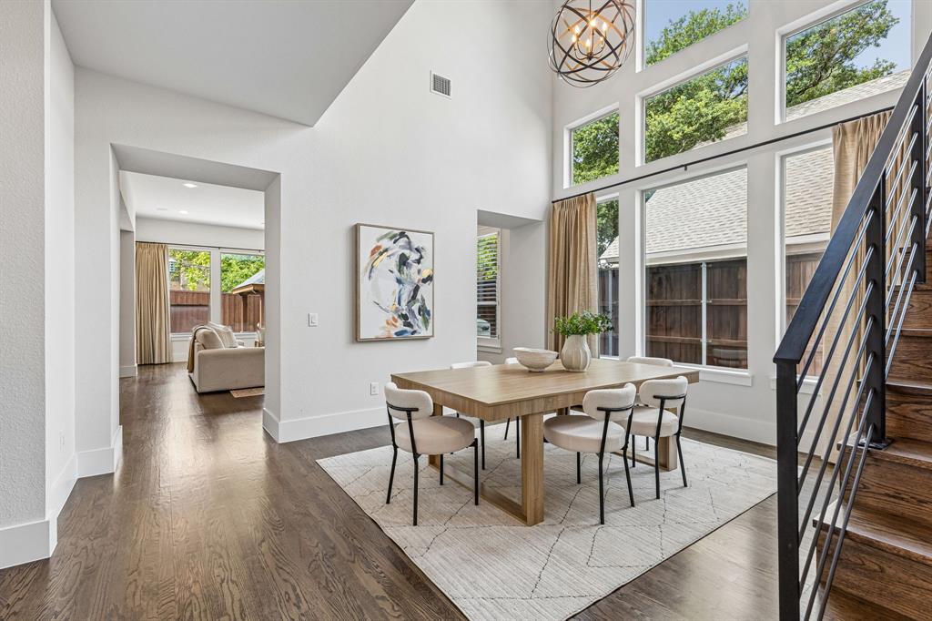 Vaulted ceilings featuring a spherical metal chandelier, expansive multi-tier windows, and dark wood-finish flooring
