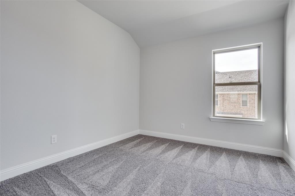 Neutral-toned interior room featuring crisp walls, patterned carpeting, and a single-pane window