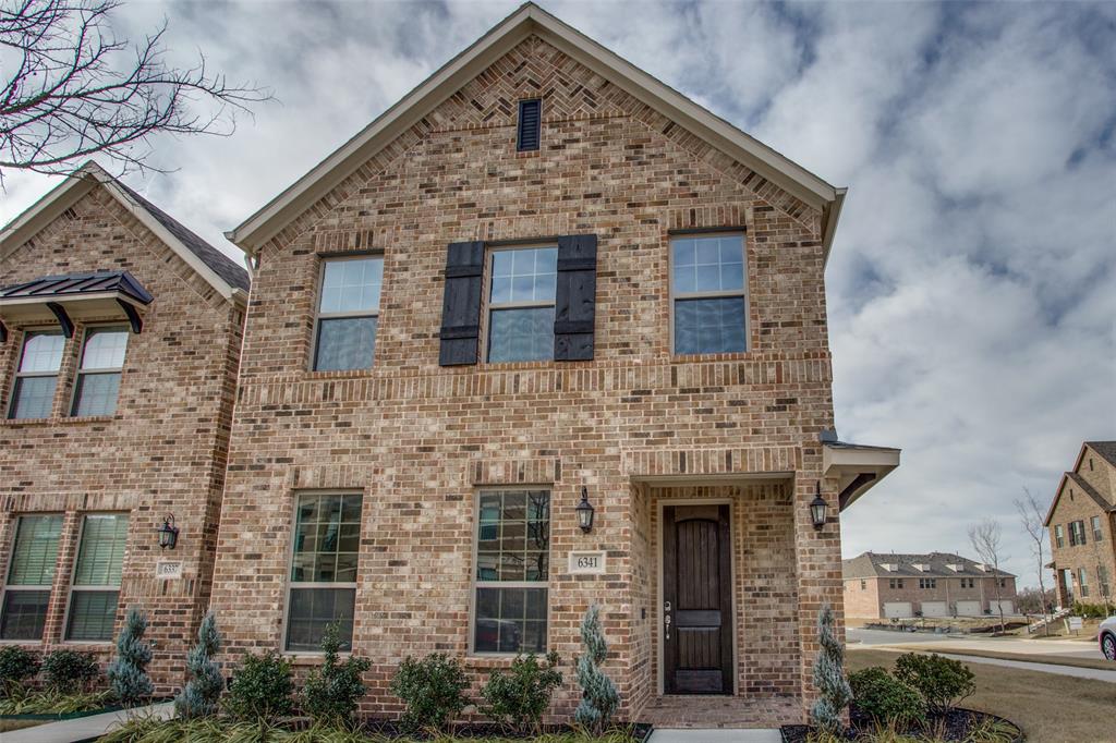 Traditional brick exterior featuring a herringbone masonry gable accent, dark wood-finish front door, and decorative window shutters Traditional brick exterior featuring a herringbone masonry gable accent, dark wood-finish front door, and decorative window shutters