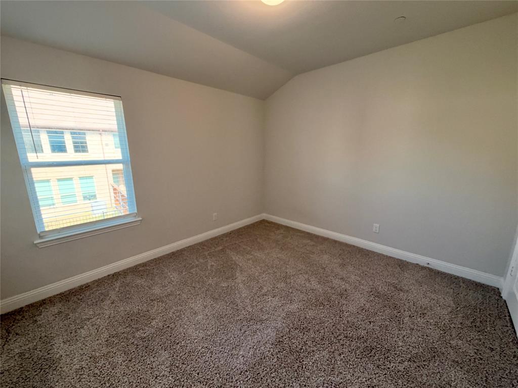 Vaulted ceiling, neutral wall tones, textured carpeting, and single-pane window with horizontal blinds Vaulted ceiling, neutral wall tones, textured carpeting, and single-pane window with horizontal blinds