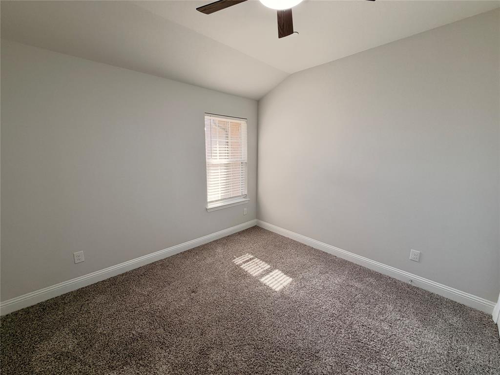 Vaulted ceiling with a centrally mounted ceiling fan, neutral wall finishes, plush wall-to-wall carpeting, and a single-hung window with horizontal blinds Vaulted ceiling with a centrally mounted ceiling fan, neutral wall finishes, plush wall-to-wall carpeting, and a single-hung window with horizontal blinds