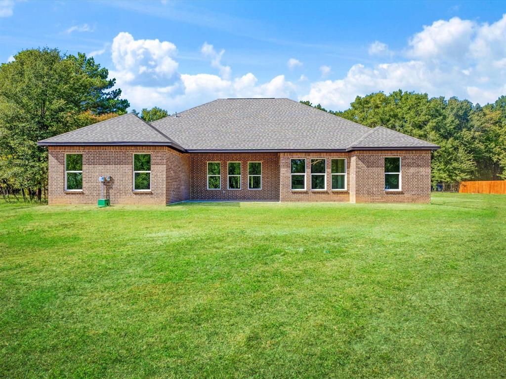 Brick exterior, architectural shingle roof, and expansive lawn area