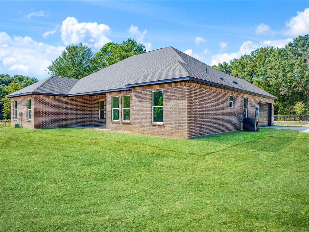 Brick exterior, hipped roofline, and expansive manicured lawn