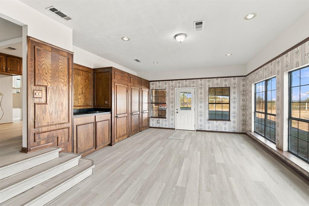 Bar area, cabinets, door to covered patio, and windows to the backyard