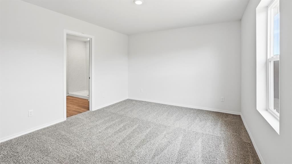 Carpeted room with white walls, recessed lighting, and a single window