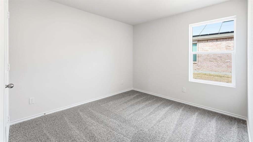 Neutral wall paint, gray carpet flooring, white trim, and a white-framed window