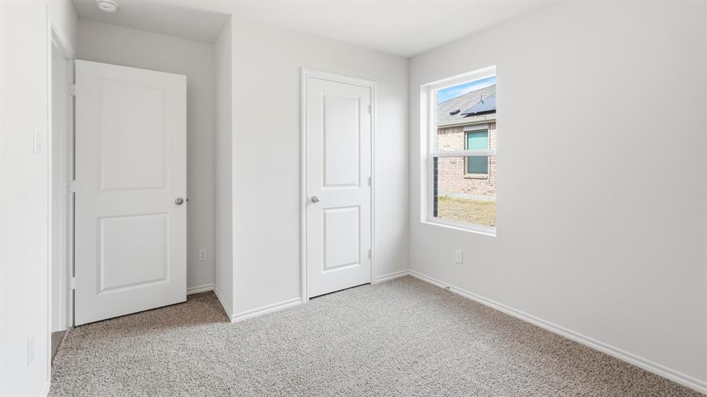 Carpeted room featuring a double-pane window, white trim, and two paneled doors