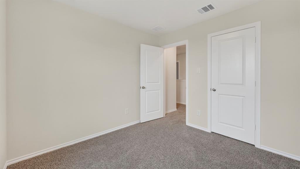 Room featuring light gray wall paint, gray carpeting, white baseboards, and white paneled doors