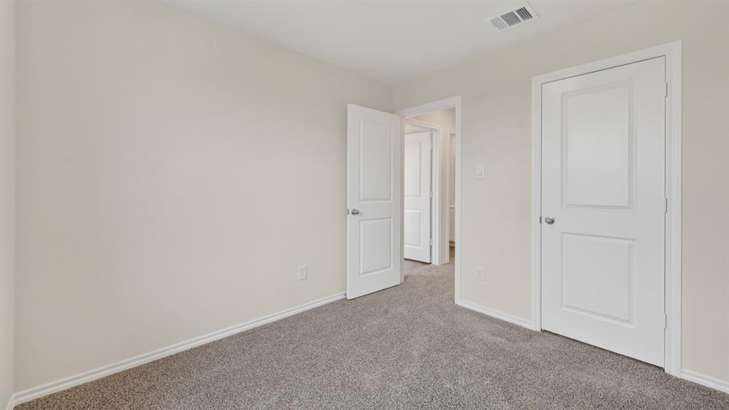 Neutral wall tones complement the gray carpeted flooring