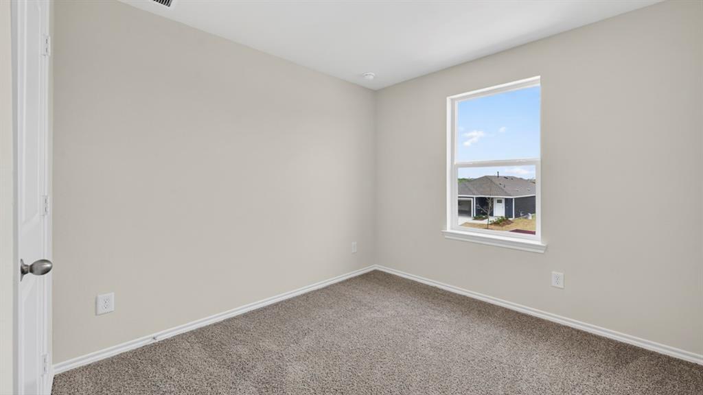 Neutral-toned room featuring a single window, light gray walls, gray carpet, and white trim